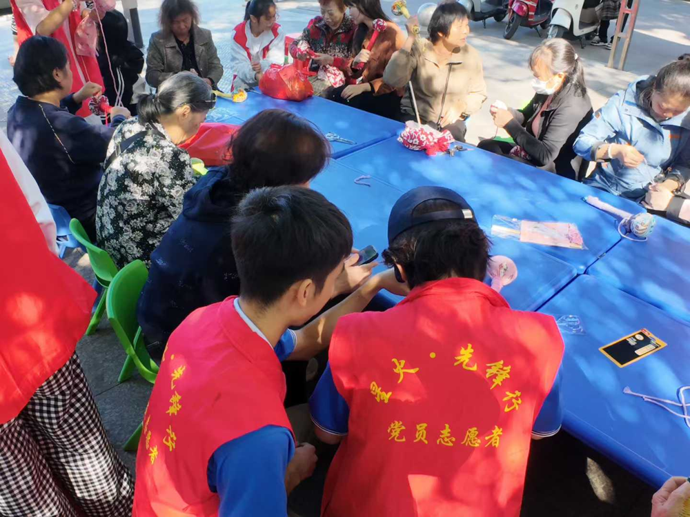 同学们和老人一起制作艾草锤